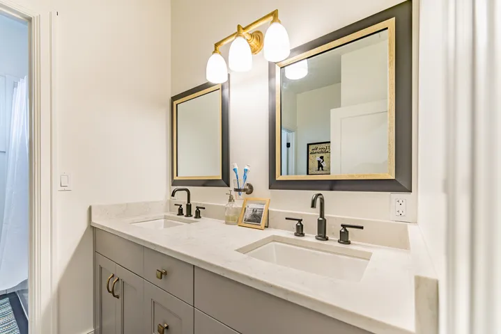Double vanity with light gray cabinetry, integrated sinks, and light-toned countertops