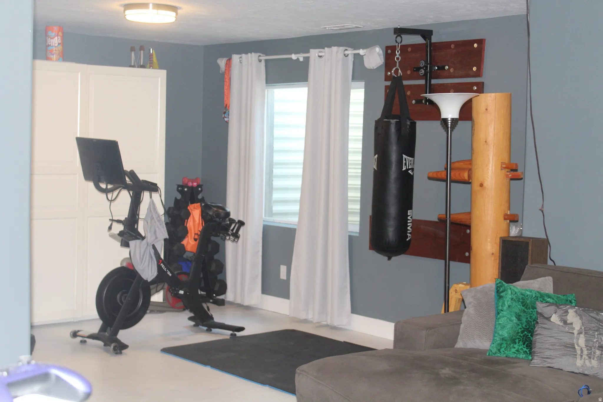 Recessed lighting, light gray walls, built-in storage cabinet, window with horizontal blinds, and a durable flooring surface