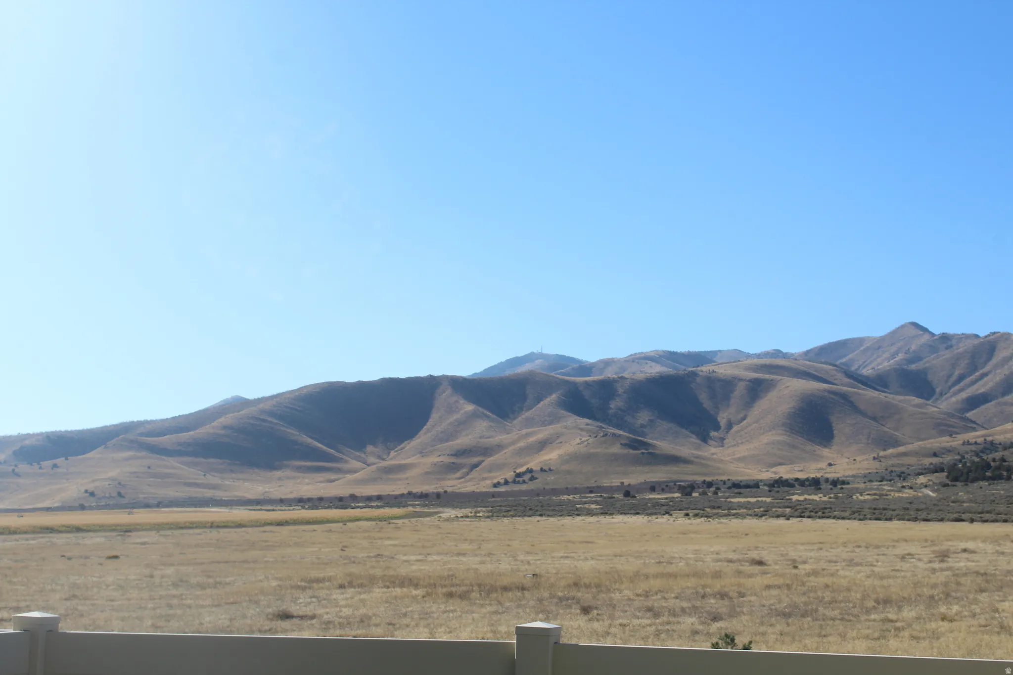 Expansive natural landscape with rolling hills and a visible clear sky