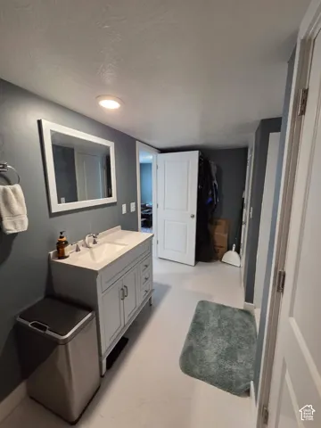 White vanity with dual doors and three drawers, undermount sink, and polished chrome faucet