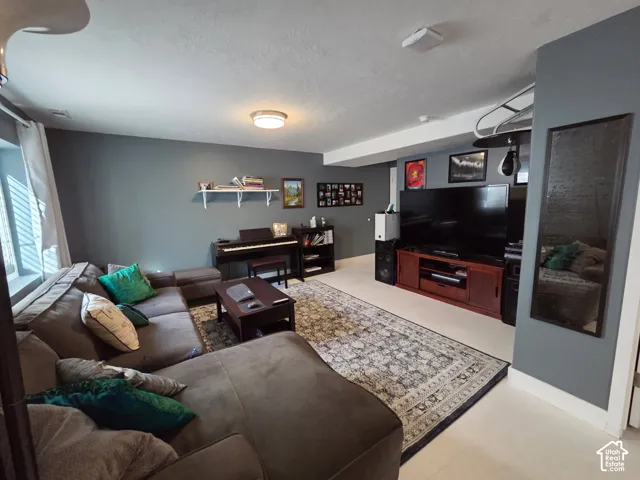 Recessed ceiling lighting, a wall-mounted shelf, built-in media console, and a window with blinds