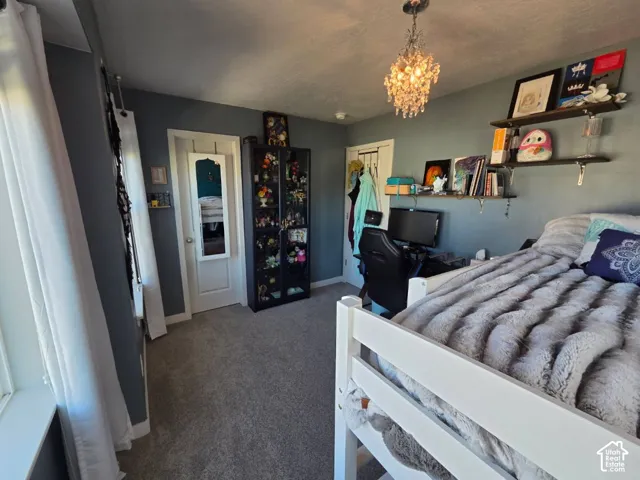 Carpeted flooring, a white window frame, and a crystal chandelier