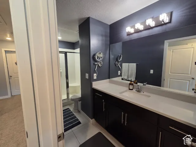 Integrated vanity with a single basin sink, white countertop, and dark wood-finish cabinetry