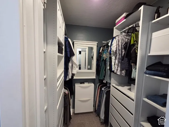 Custom built-in closet organization system featuring white shelving, drawers, and hanging rods
