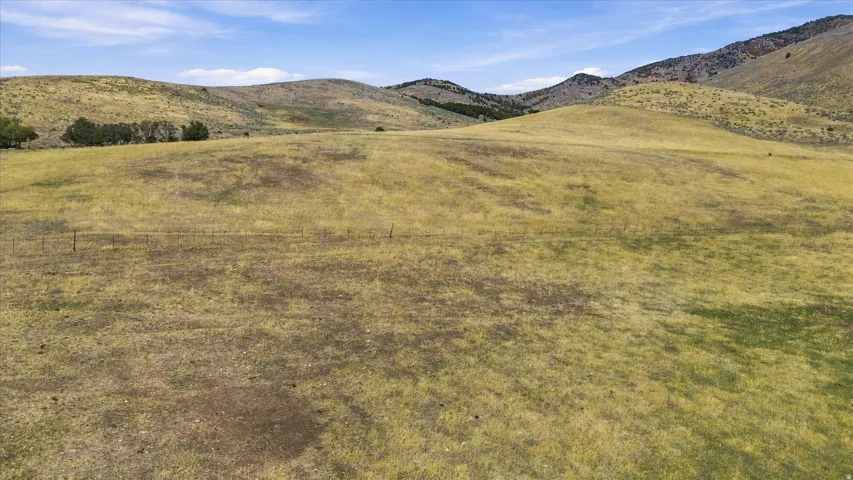 Expansive undeveloped land featuring rolling hills and distant mountains