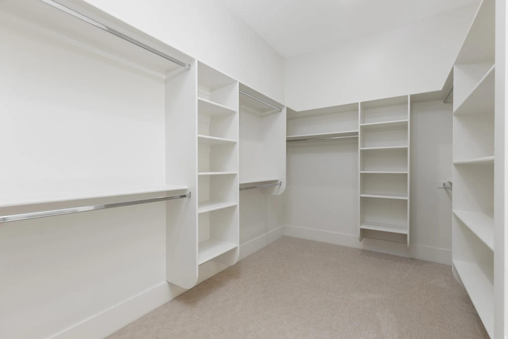 Custom closet system with multiple shelving units and hanging rods