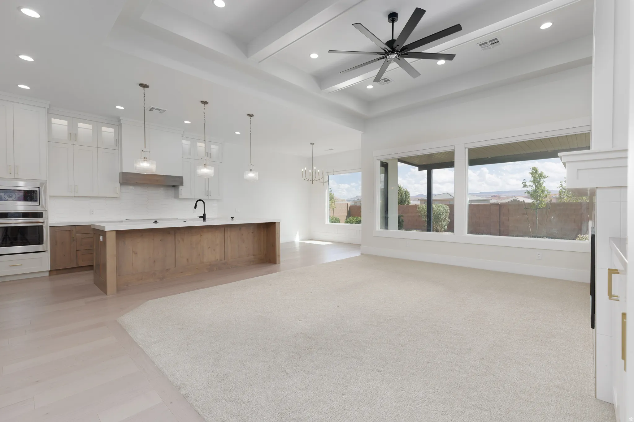 Open concept living area with tray ceiling, recessed lighting, and a modern ceiling fan