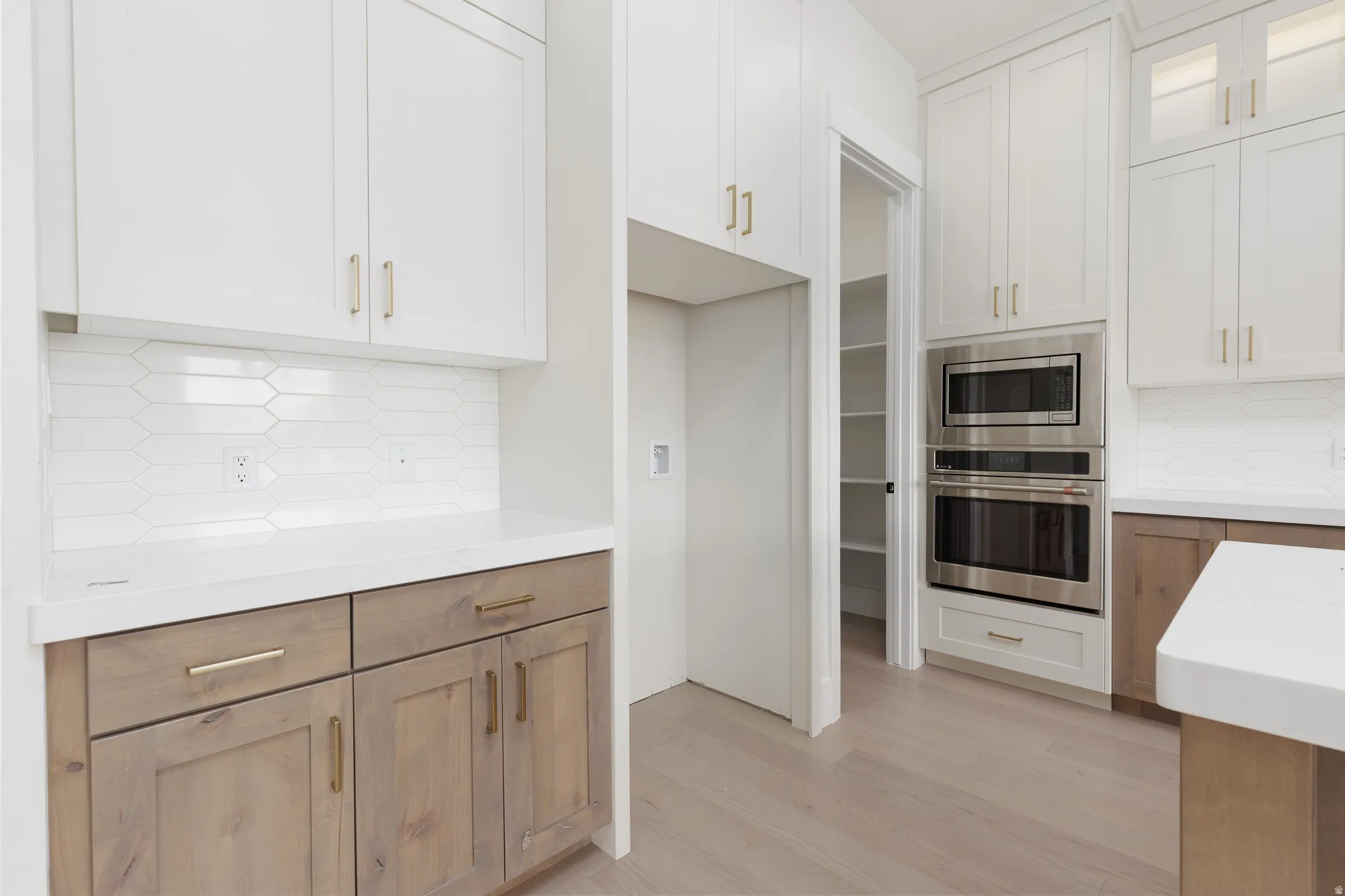 White shaker cabinetry with gold-tone hardware