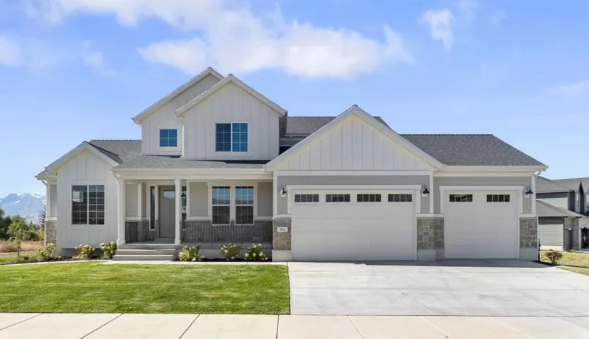 Contemporary farmhouse exterior with board and batten siding, stone accents, covered porch, and a three-car garage