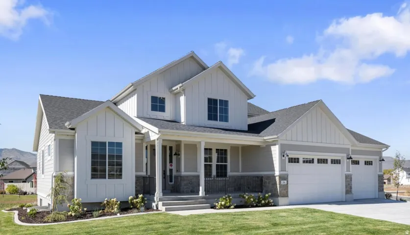 Modern farmhouse exterior featuring board and batten siding, a covered front porch, an attached two-car garage, and a concrete driveway
