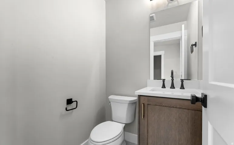 Modern vanity with wood-finish cabinetry, white countertop, and integrated sink