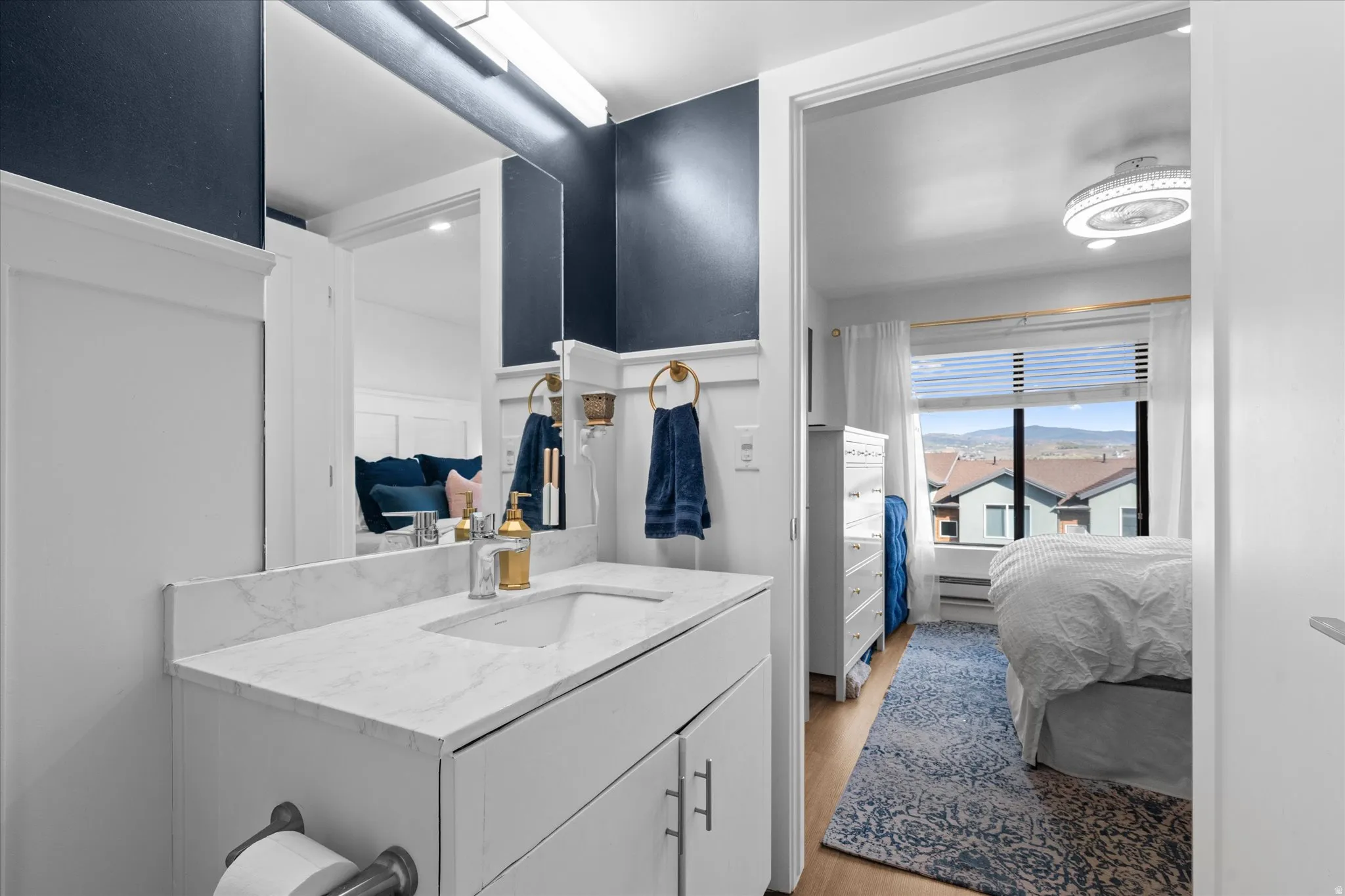 White vanity with a stone-finish countertop and integrated sink