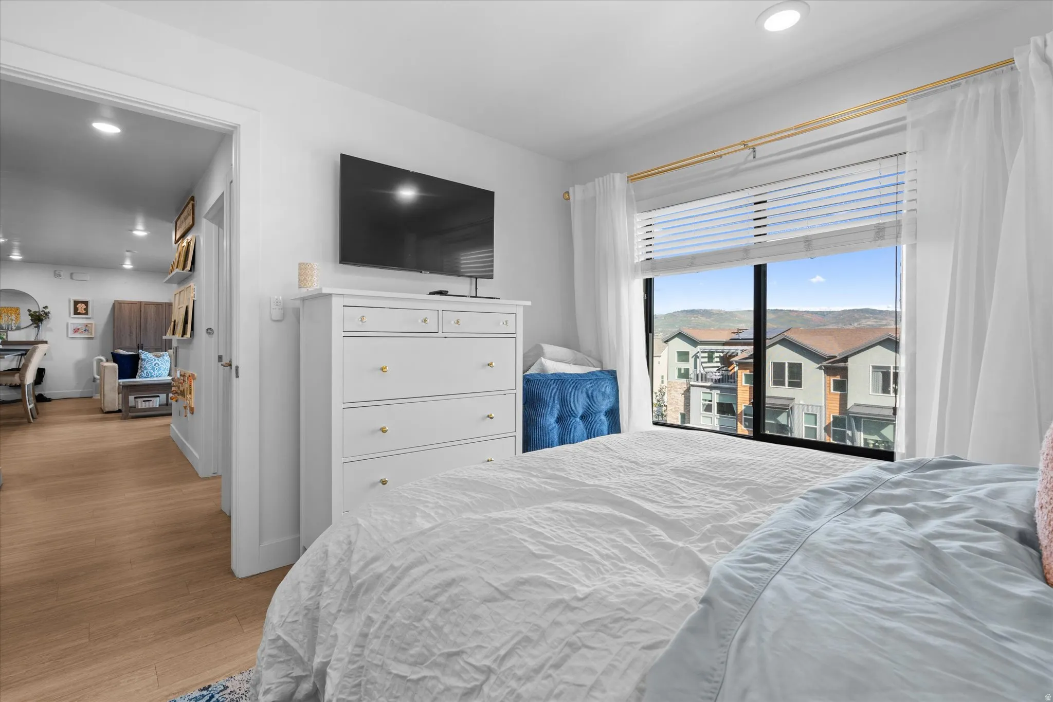 Expansive window with black framing, recessed lighting, and wood-finish flooring