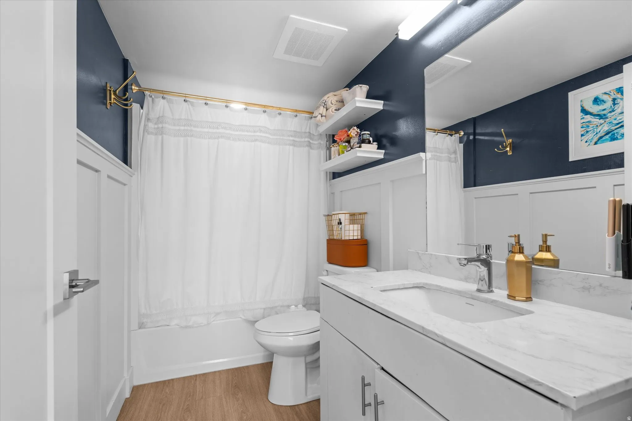 White vanity with a stone-finish countertop, single basin sink, and chrome faucet