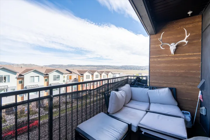 Balcony featuring a black metal railing and wood-tone wall paneling