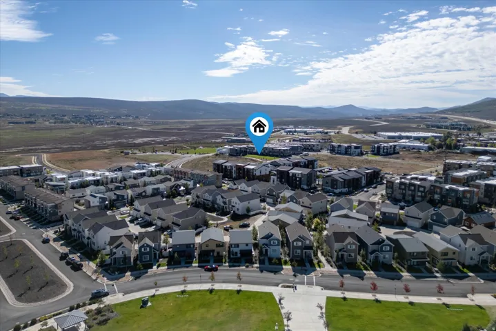Aerial perspective showcasing a residential community with diverse housing styles, including multi-story townhomes and single-family residences