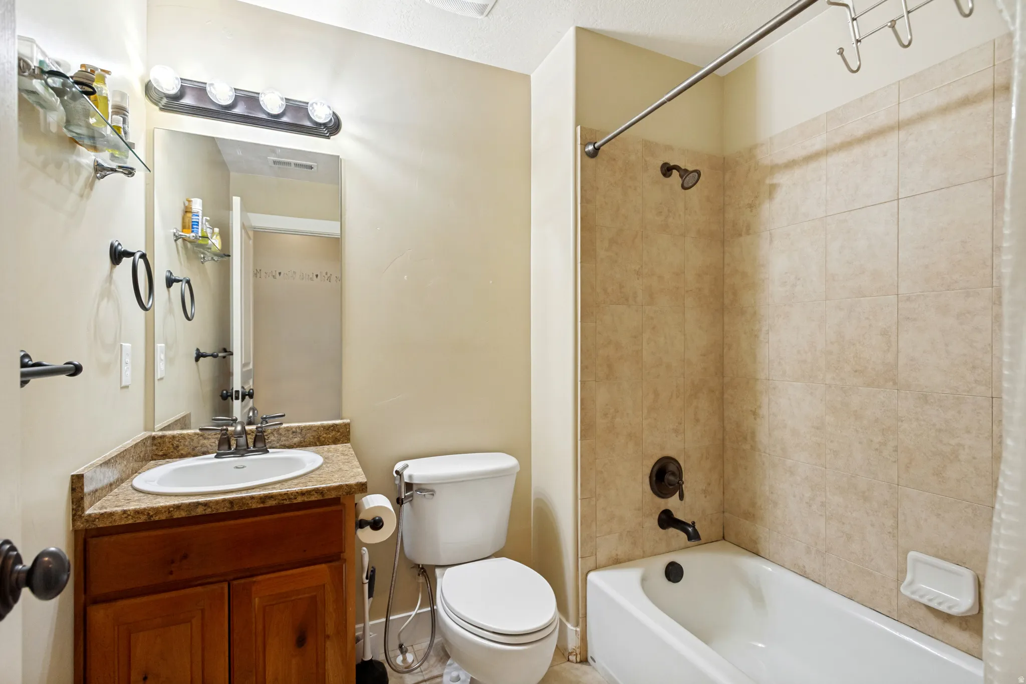 Bathroom featuring a vanity with an integrated sink, a dark wood-finish cabinet, and a framed mirror with overhead lighting
