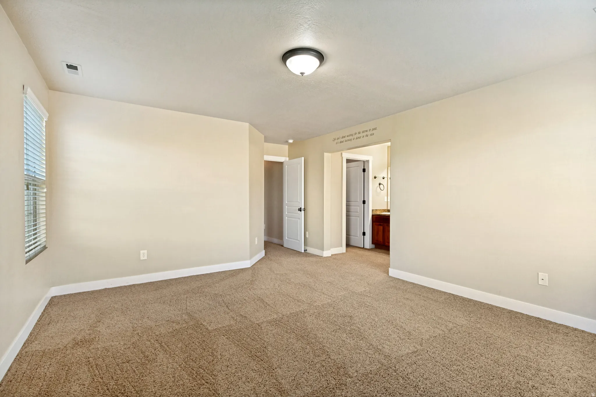Neutral wall tones, recessed window, and brown carpeting