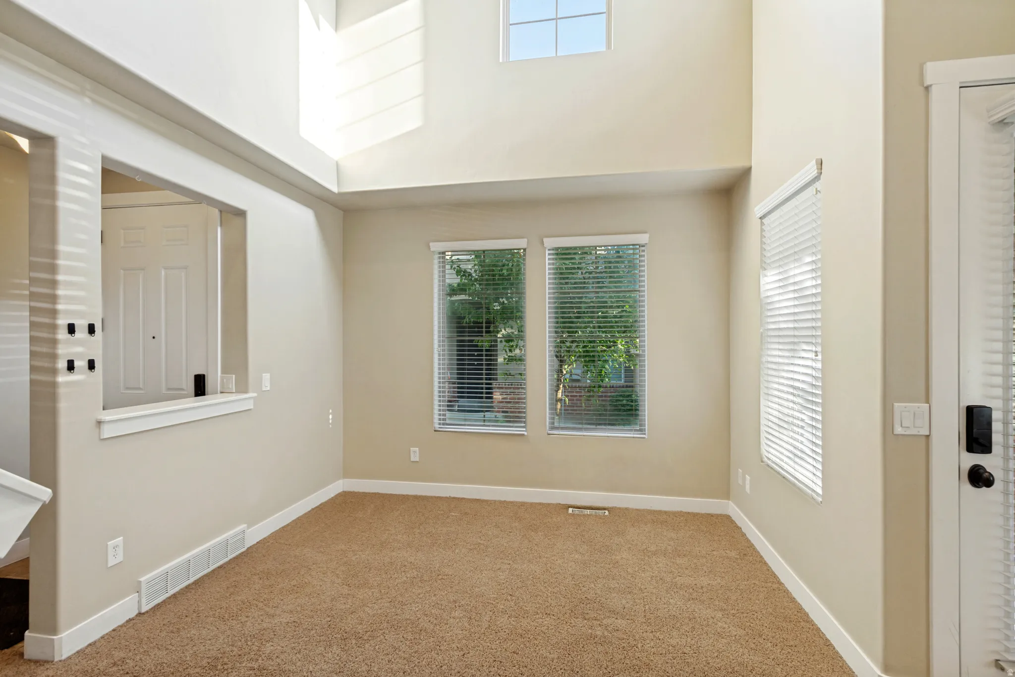 Vaulted ceiling, upper windows, double-pane windows, carpet flooring, base molding