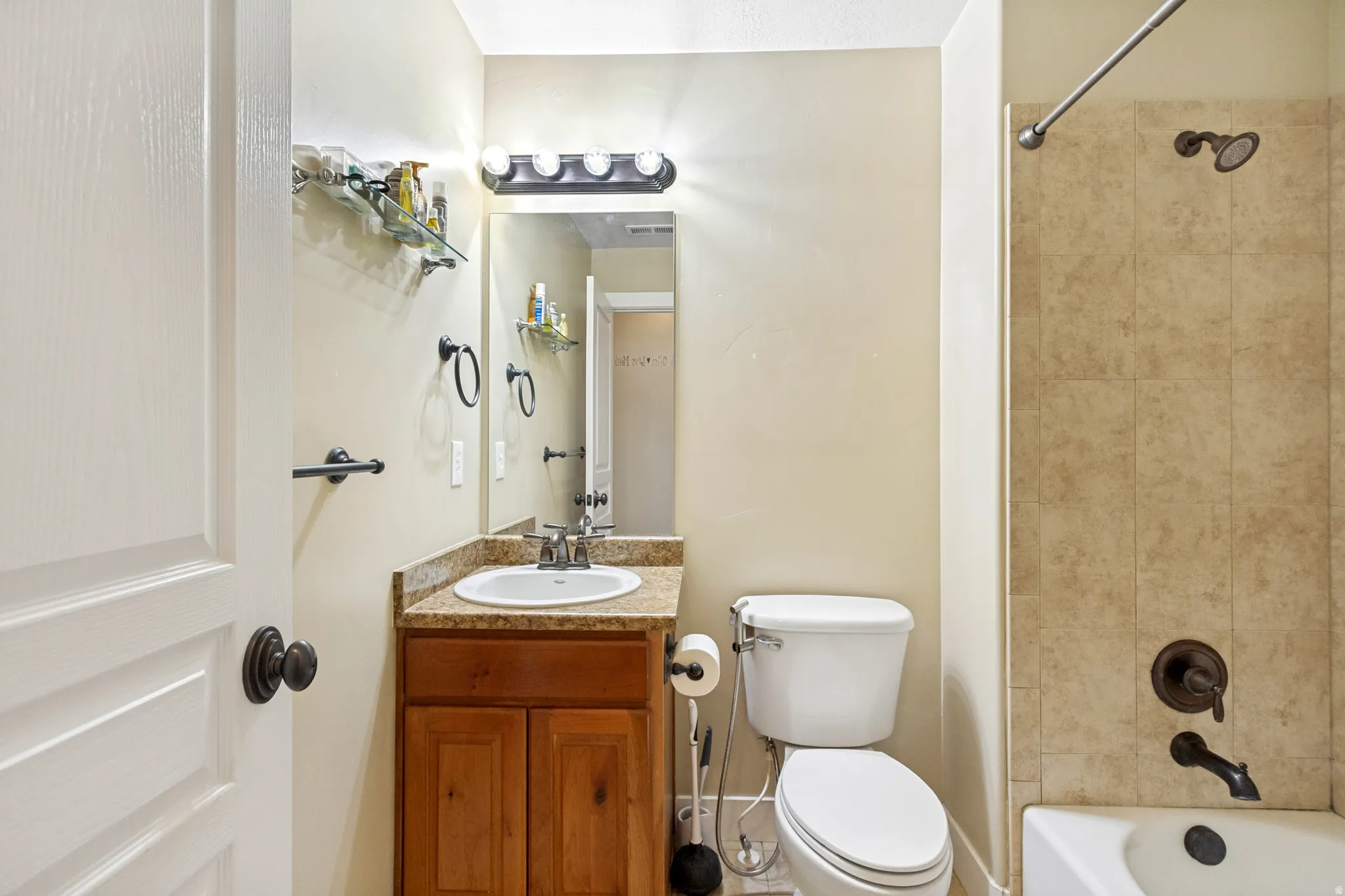 Wood-finish vanity with an undermount sink and granite-finish countertop