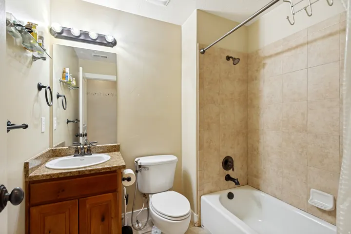 Bathroom featuring a vanity with an integrated sink, a dark wood-finish cabinet, and a framed mirror with overhead lighting