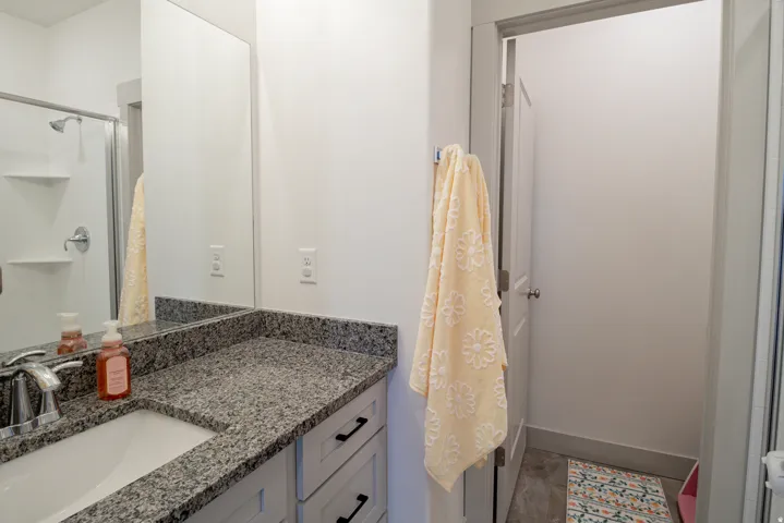 Vanity with granite-finish countertop, undermount sink, and chrome faucet