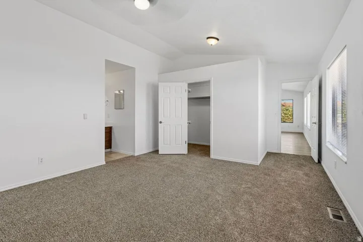 Carpeted room with white walls, a built-in closet, and a ceiling fan