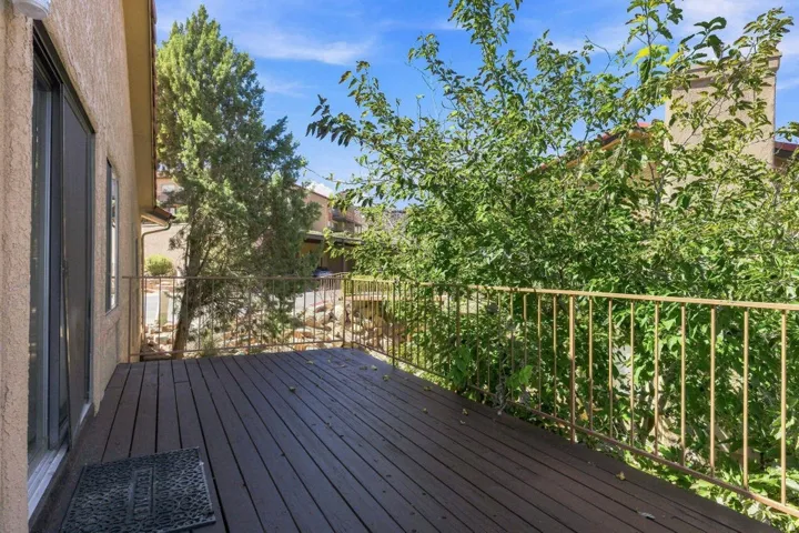 Outdoor deck with rich wood-finish flooring and a decorative metal railing