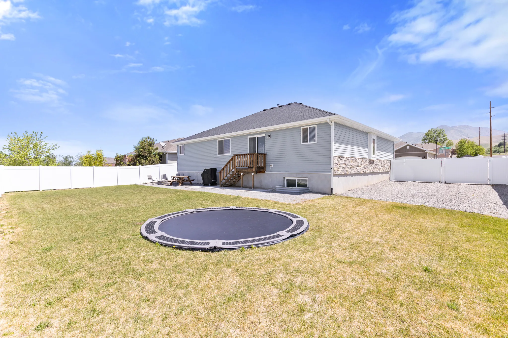 Spacious backyard with a white privacy fence and gravel side yard