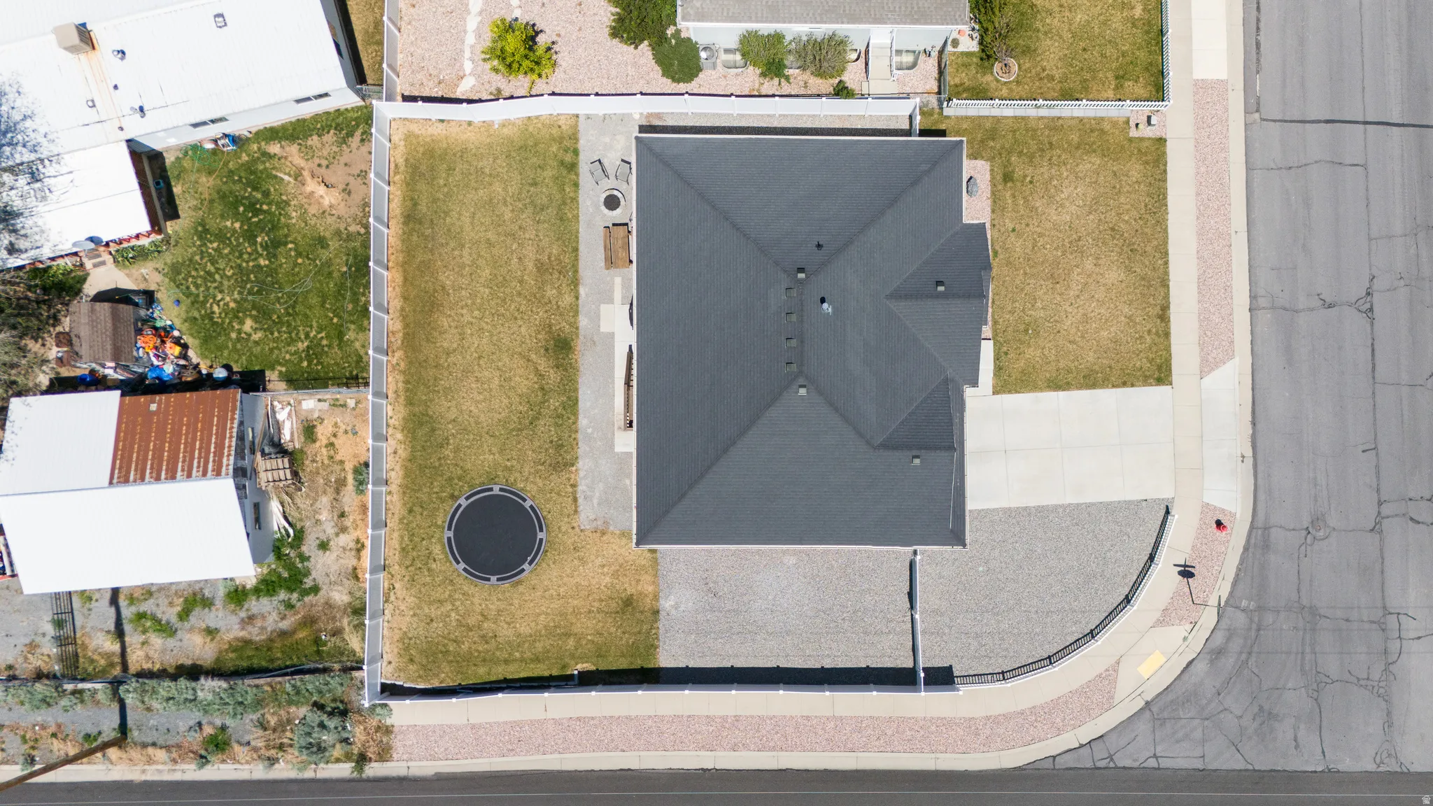 Pitched roofline, white privacy fencing, concrete patio, grass lawn, gravel landscaping