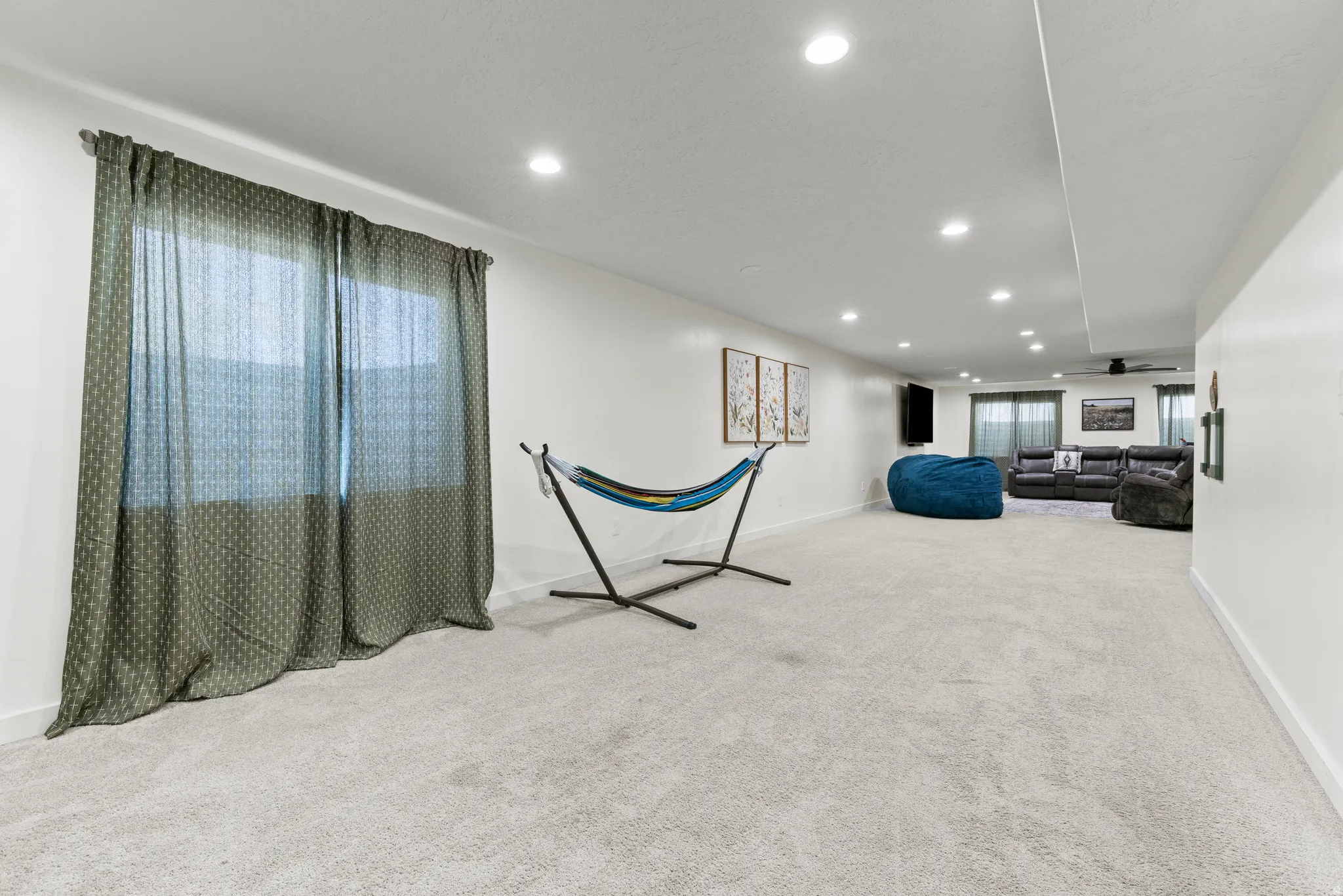 Recessed lighting, light-colored carpet, white walls, and a window with blinds