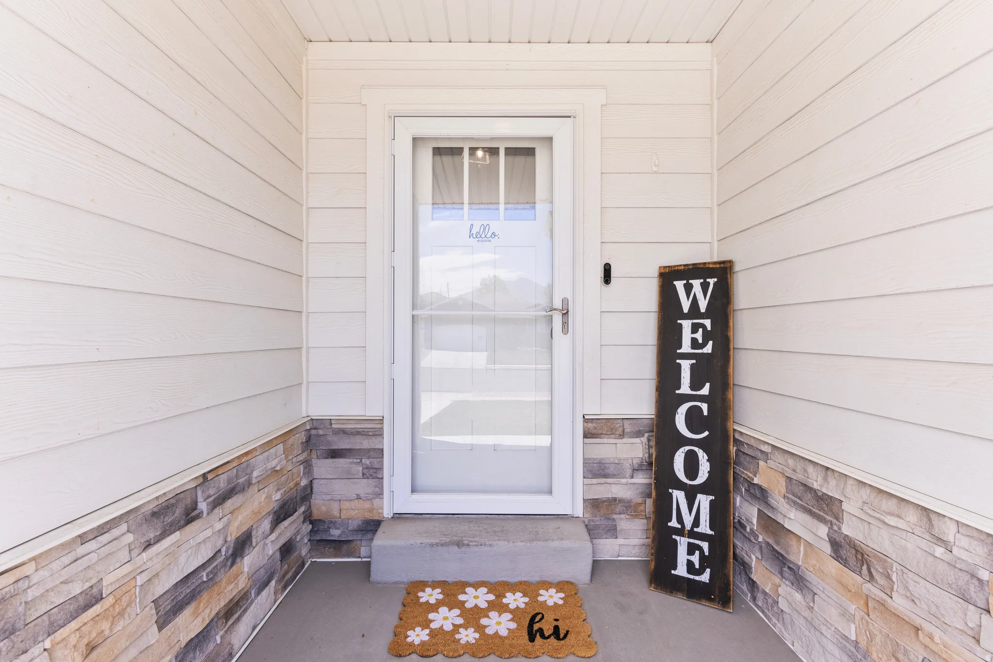 White siding exterior with a stone veneer accent