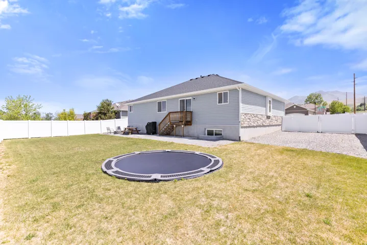 Spacious backyard with a white privacy fence and gravel side yard