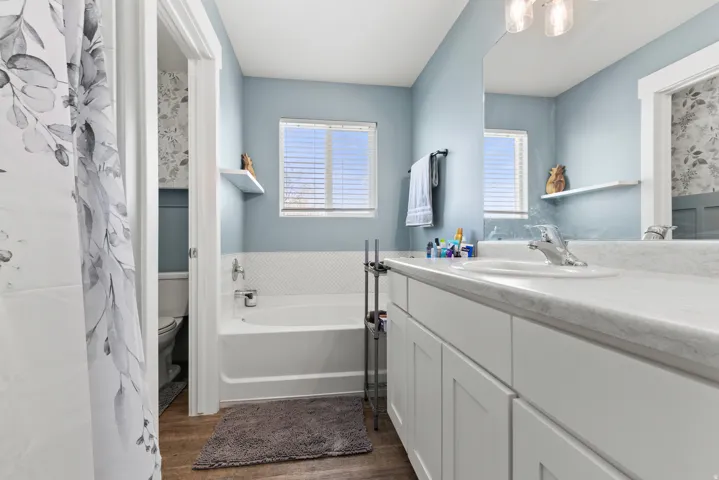 Single vanity with integrated sink, white cabinetry, and a light-toned countertop
