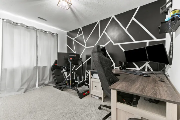 Geometric accent wall with light carpet flooring