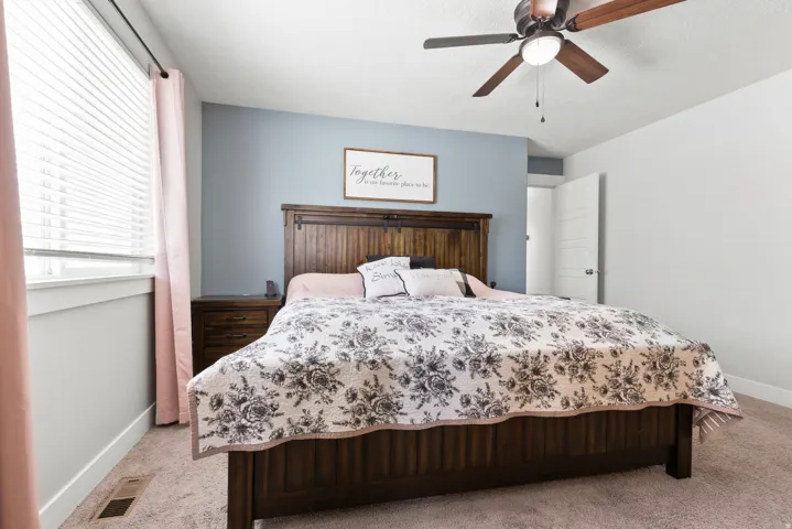 Recessed lighting, ceiling fan with wood-finish blades, and window with blinds