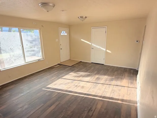 Wood-finish flooring, neutral wall tones, white trim, and a semi-flush mount ceiling fixture