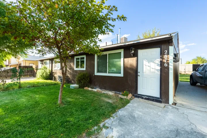 Single-story property with brown exterior siding and white trim windows