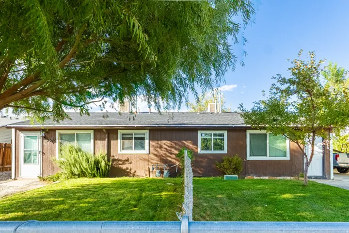 Brown exterior siding with white window frames and a dark shingle roof