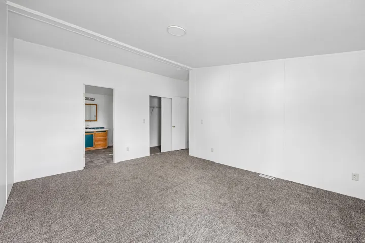 Neutral tone-on-tone carpeting, white panel walls, and a recessed ceiling light fixture
