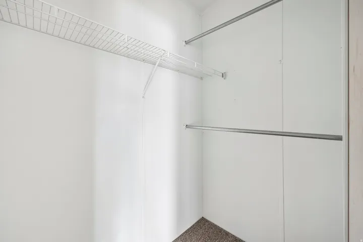 White wire shelving and two metal hanging rods