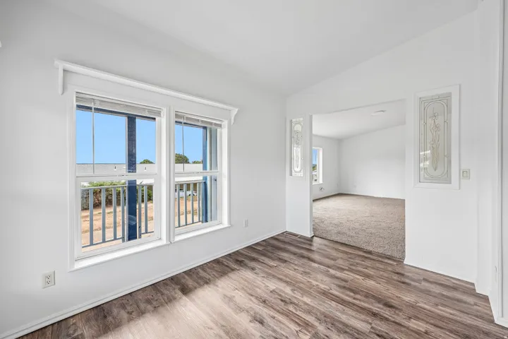 Wood-finish flooring, white walls, double-hung windows, and decorative glass panels