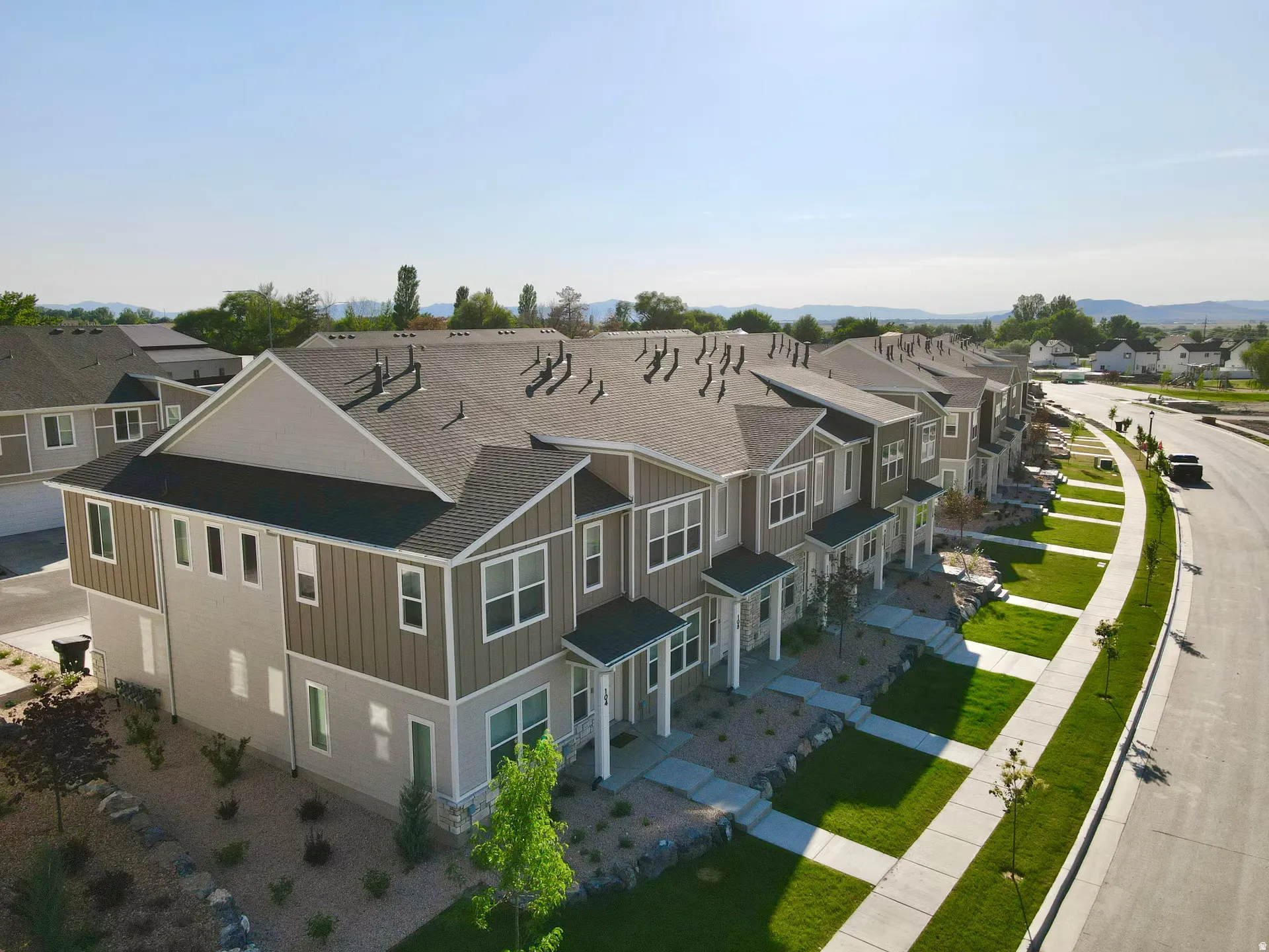 Modern townhome exteriors featuring gabled roofs, horizontal siding, and covered entryways