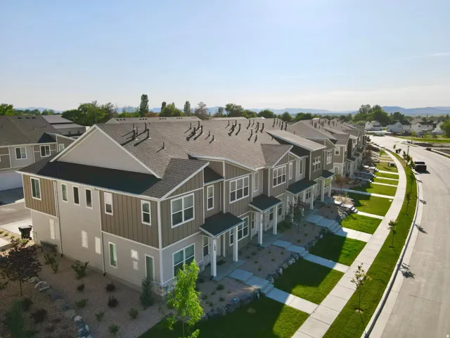 Modern townhome exteriors featuring gabled roofs, horizontal siding, and covered entryways