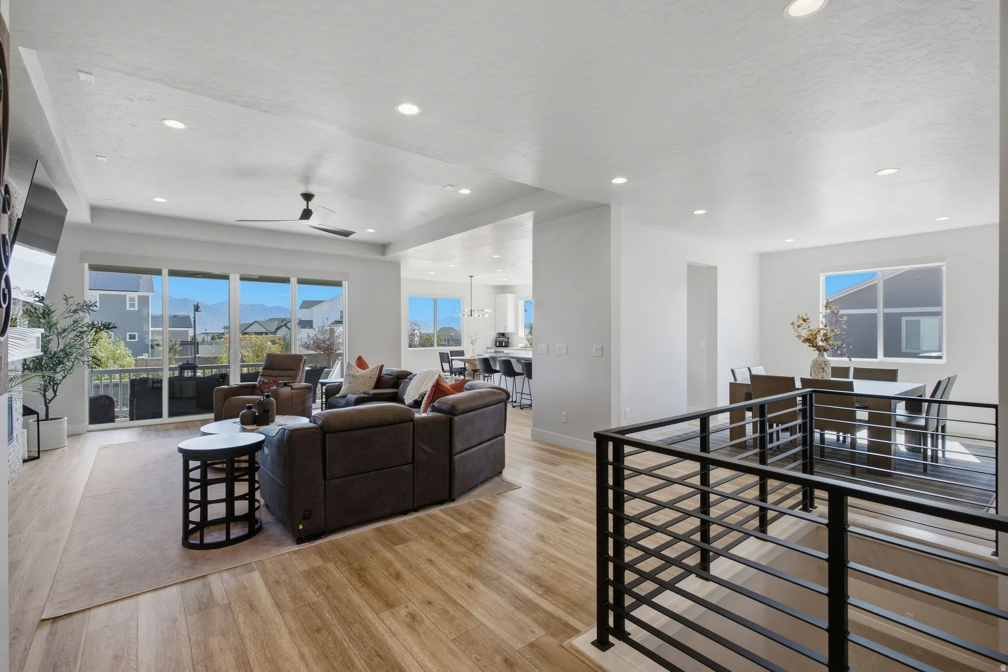 Open-concept living area with LVP flooring, recessed lighting.
