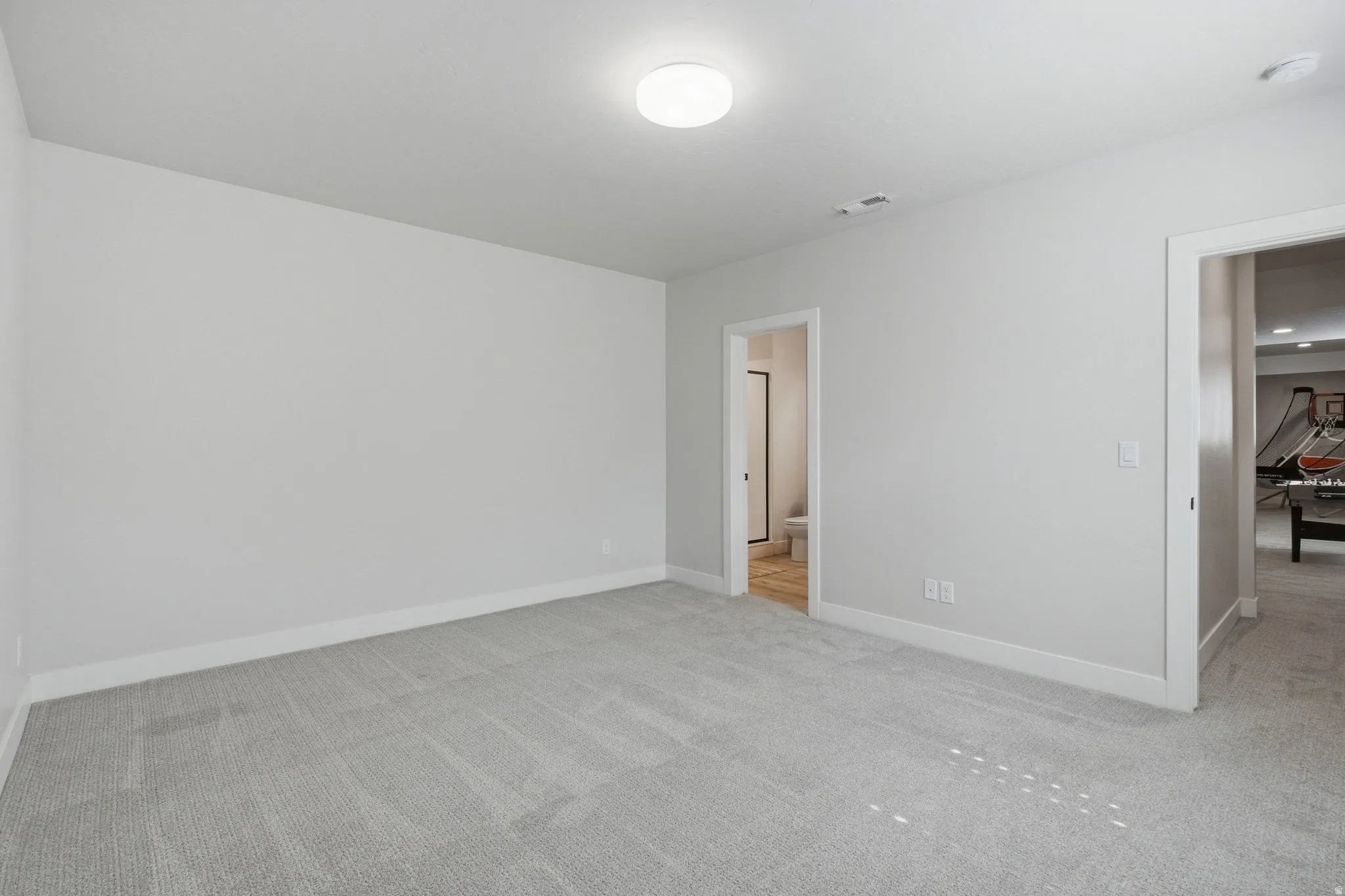 Light gray carpeting, neutral wall color, white trim, recessed ceiling light.
