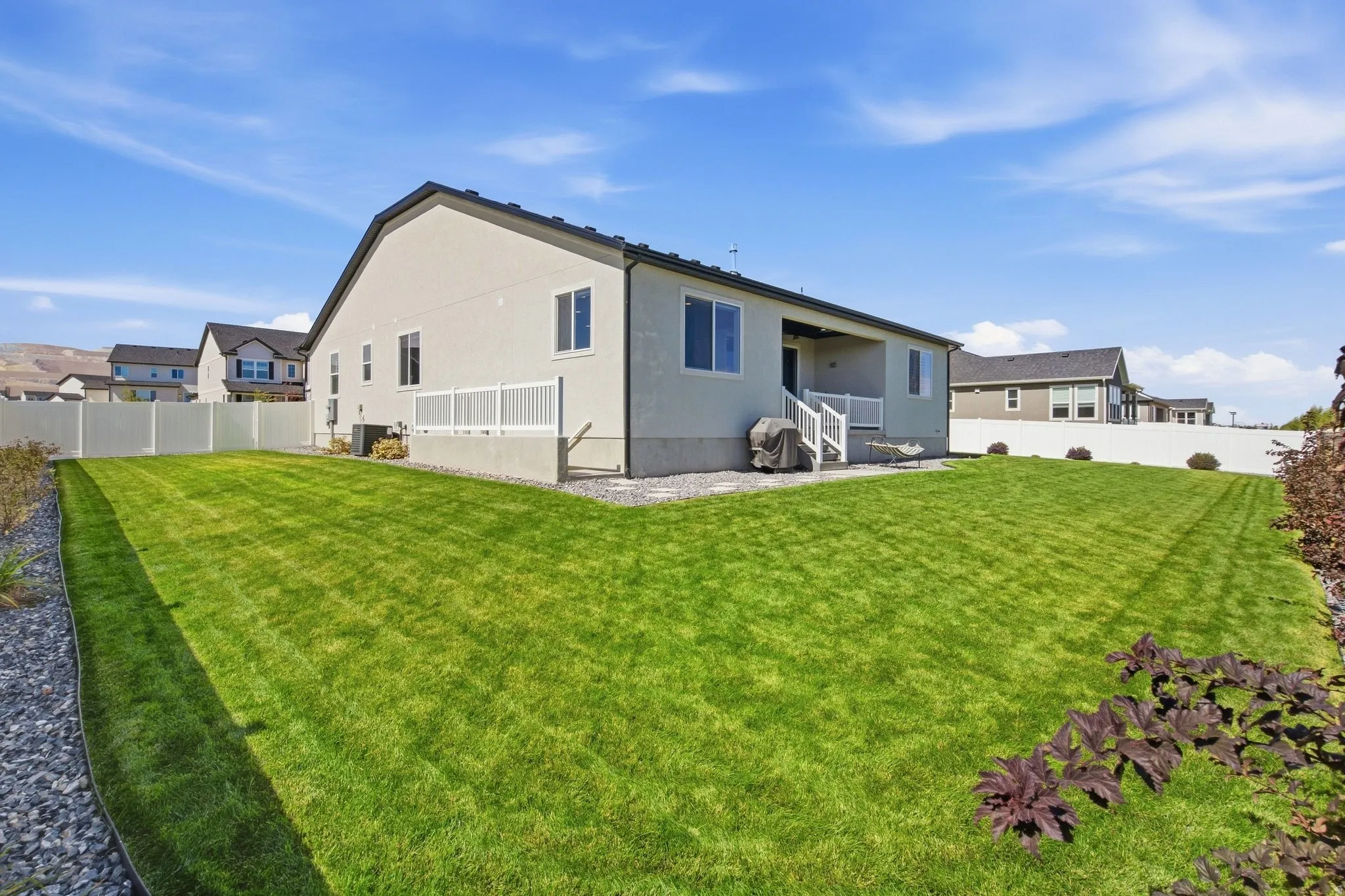 Expansive backyard with manicured lawn, fully fenced.