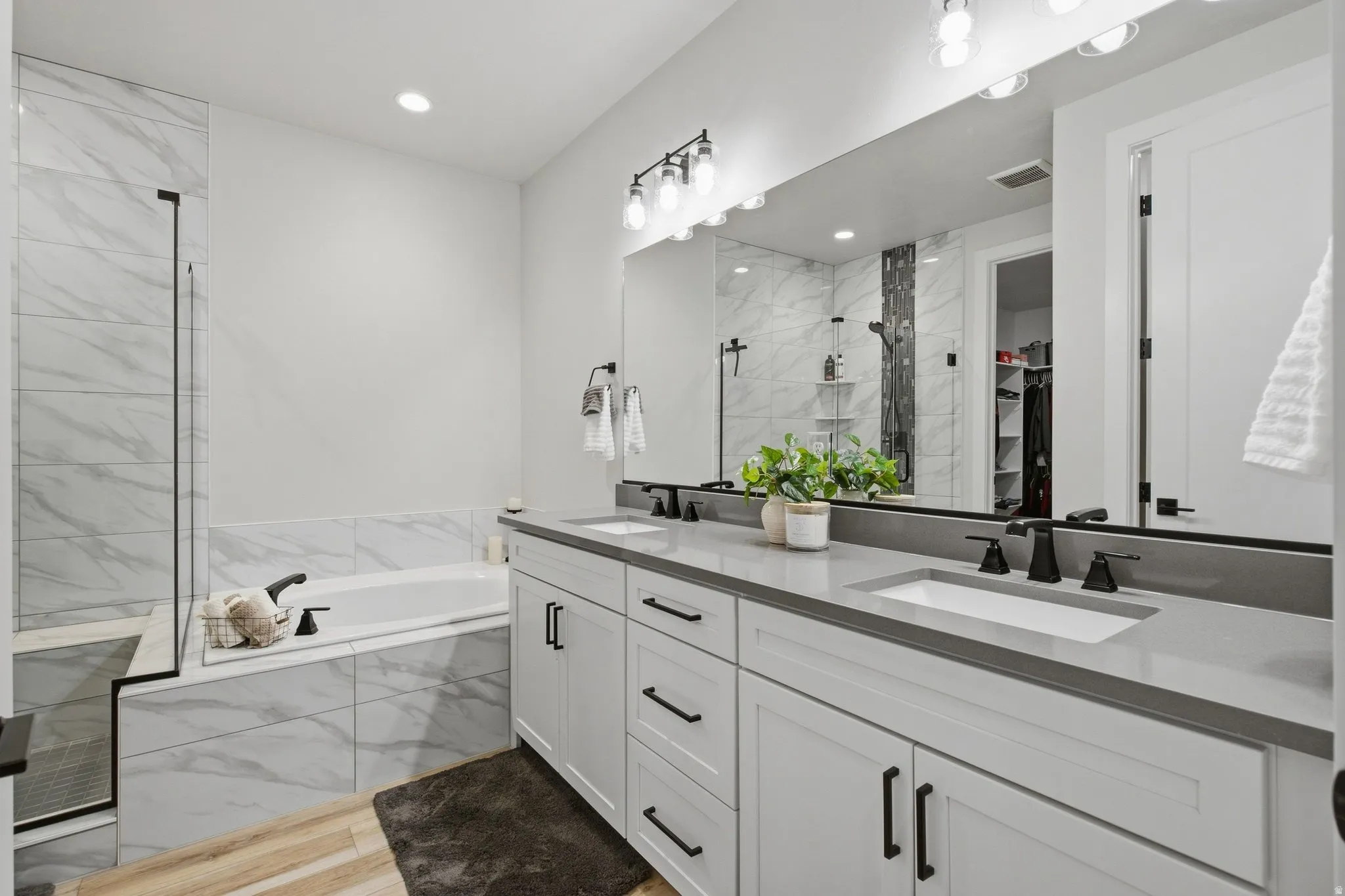 Primary En-suite with dual vanity, quartz countertops, and matte black fixtures.