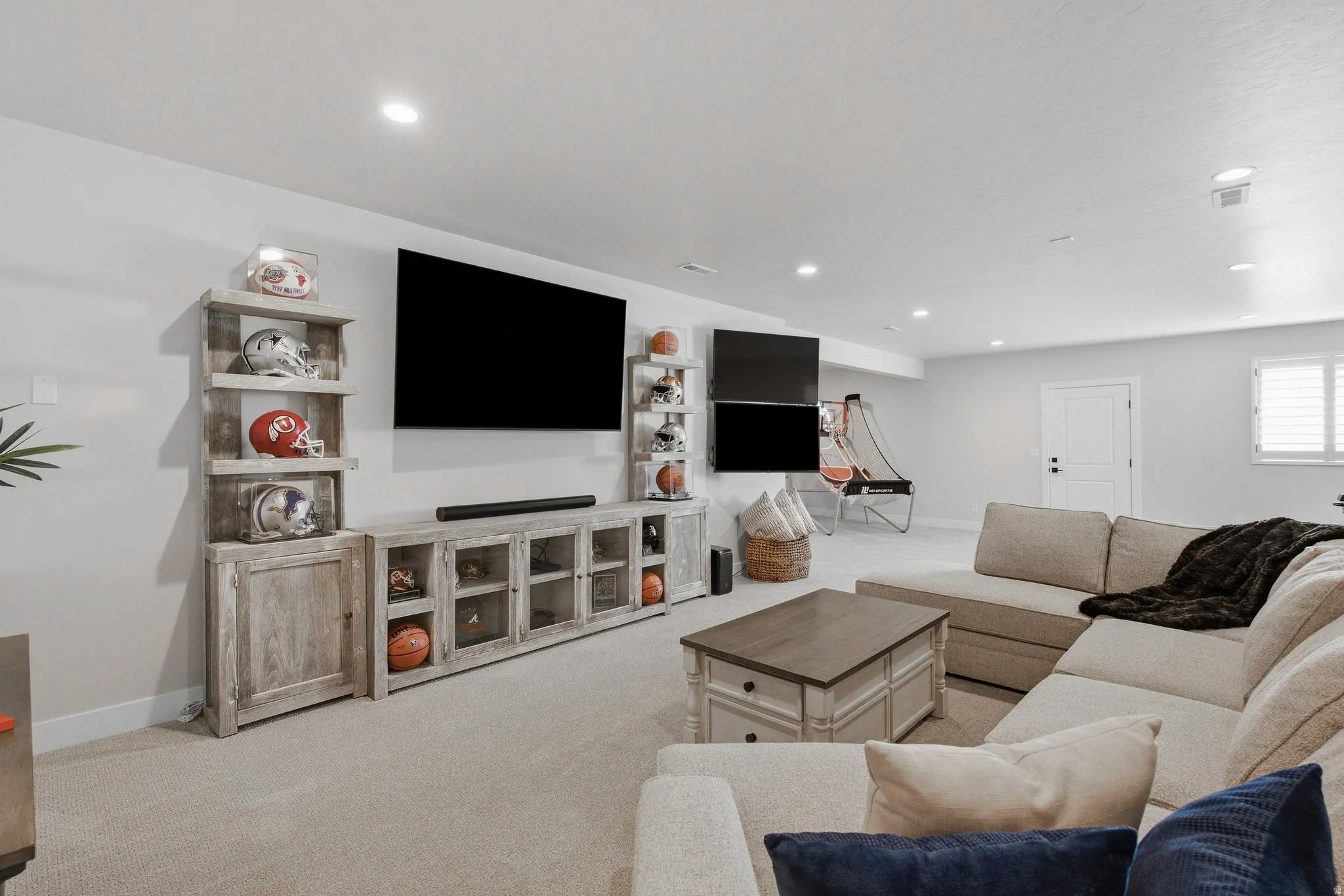 Recessed lighting, carpeted flooring, and window with white shutters.