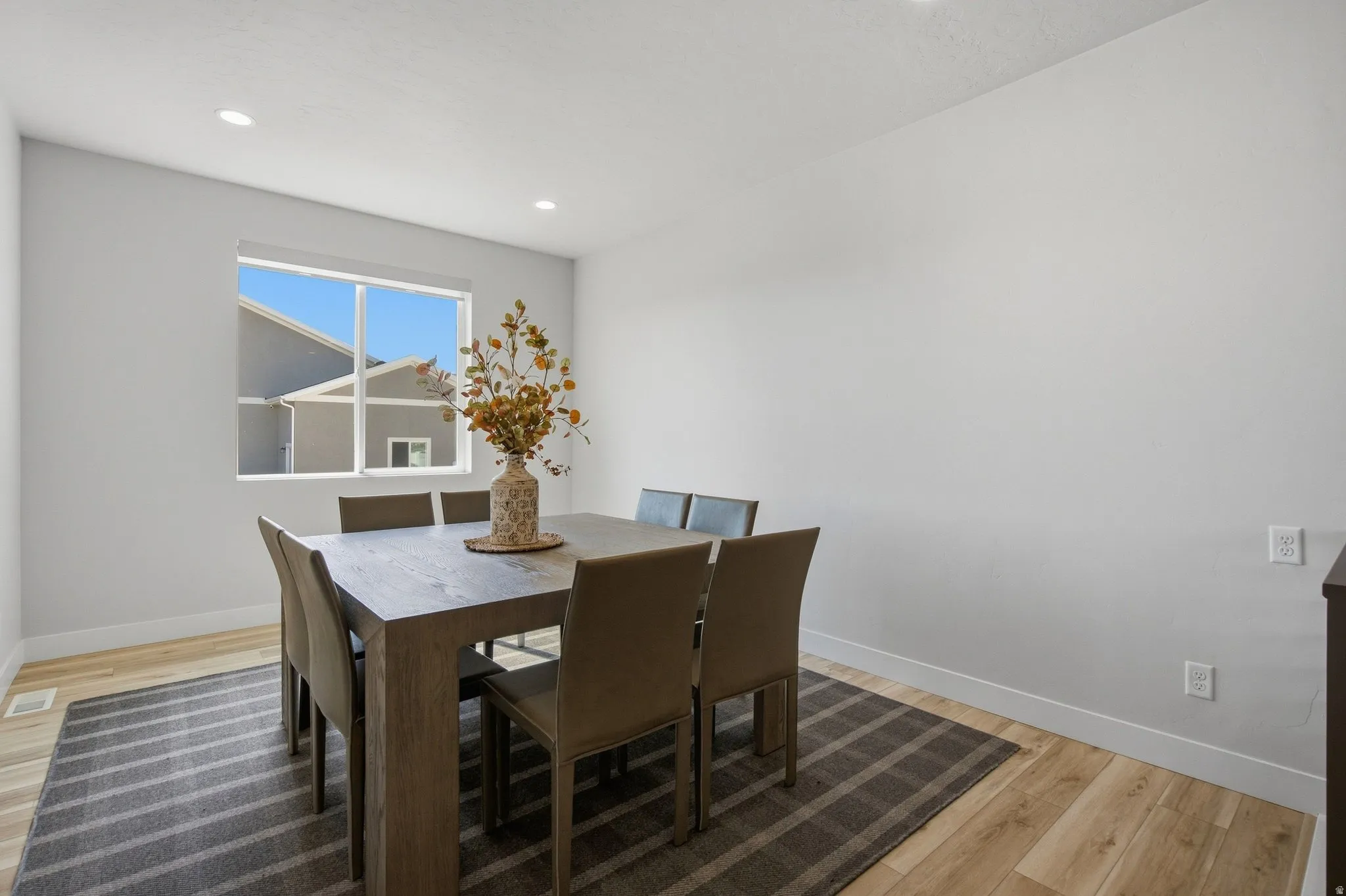 Recessed lighting illuminates the room with LVP wood-finish flooring.